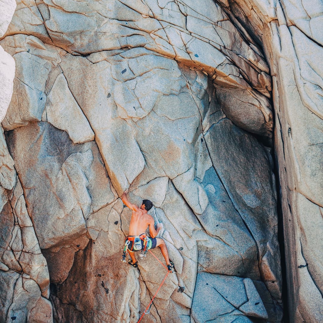 Homme escaladant sur rocher en tête